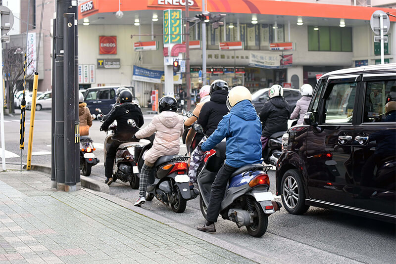 信号が赤になると車線が原付で埋まる ※交差点には二輪専用の停止線もある